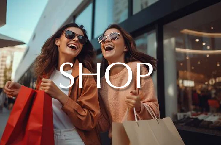 Two women smiling while holding shopping bags outside retail shops in Greater Noida.